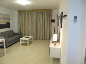 ein Wohnzimmer mit einem Sofa und einem Tisch in der Unterkunft Apartamento " El Pueblo" in Mogán