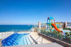 a swimming pool with a slide and a playground at Apartamento en Santa Marta frente al mar in Gaira