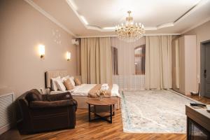 a living room with a couch and a chandelier at Prima Villa Boutique Hotel отель in Semey
