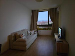 a living room with a couch and a large window at AspenValley Aprtment in Razlog