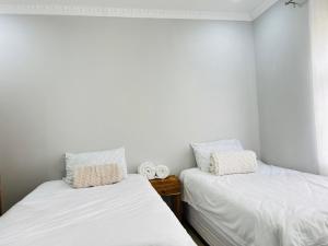 two beds sitting next to each other in a room at Pwake Luna Guesthouse in Swakopmund +23 photos