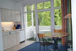 a kitchen with a table and chairs and a window at "Residenz Seeblick" Studio 23 mit seitlichem Ostseeblick in Ostseebad Sellin
