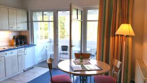 a kitchen with a table and chairs and a kitchen with a balcony at "Residenz Seeblick" Studio 23 mit seitlichem Ostseeblick in Ostseebad Sellin +41 photos