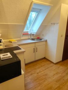 a small kitchen with a sink and a window at Apartment 10 in Surwold
