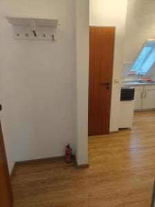 an empty room with a door and a wooden floor at Apartment 10 in Surwold