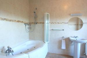 a bathroom with a tub and a sink at Bun Cill Athat in Kenmare