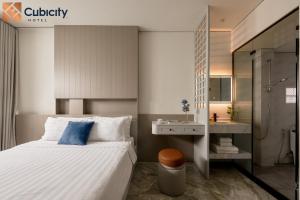 a bedroom with a large bed and a bathroom at Cubicity Ton That Tung in Ho Chi Minh City
