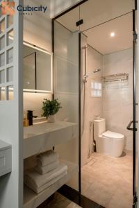 a bathroom with a sink and a toilet and a mirror at Cubicity Ton That Tung in Ho Chi Minh City +16 photos