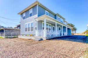 a blue house on a gravel driveway at Twin Rocks Beach Retreat in Rockaway Beach