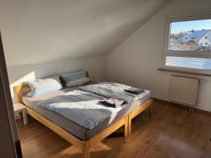 a large bed in a room with a window at Ferienwohnung an der romantischen Straße direkt A3 und A81 in Eisingen