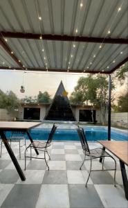 a patio with a table and chairs and a swimming pool at The triangle haven escape in Ani