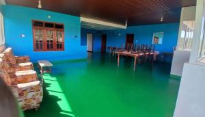 a room with blue walls and a table and chairs at Daya Guest House in Pattipola