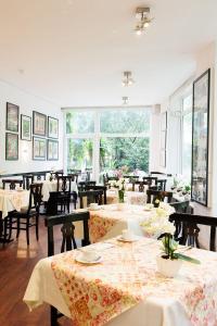 a restaurant with tables and chairs and a large window at Hotel Nymphenburg City - München in Munich +136 photos
