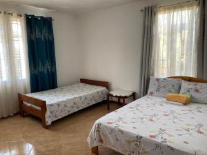 a bedroom with two beds and two windows at Shalom Villa 2 in Vacoas +12 photos