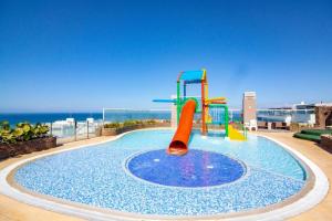 a playground with a slide in a pool with the ocean at Apartamento en Santa Marta frente al mar in Gaira
