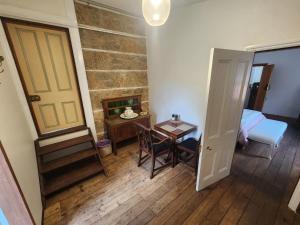 a room with a table and a door and a bedroom at Viveash - Historic accommodation with Ensuite in Hoddy Well