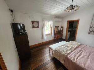 a bedroom with a bed and a television in it at Viveash - Historic accommodation with Ensuite in Hoddy Well