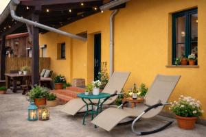 a patio with chairs and a table in front of a building at Weidelandfarm am Riebener See in Beelitz