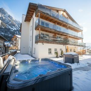 a hot tub in the snow in front of a building at Black Summit Samnaun Boutique Hotel in Samnaun