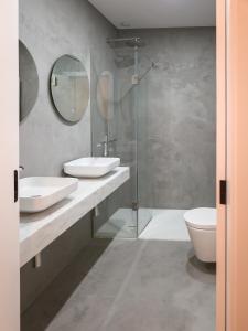 a bathroom with two sinks and a glass shower at Raposa Verde - Agroturismo in Pegarinhos +54 photos