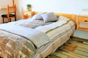 a large bed in a room with a chair at Ca la Nena Morena - Casa con piscina privada, jardín y vistas al Montseny in Vallgorguina