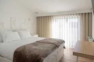 a bedroom with a bed and a large window at Raposa Verde - Agroturismo in Pegarinhos