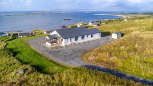an aerial view of a house on a hill next to the ocean at Makeelan House in Renvyle