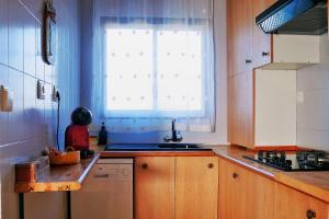 a kitchen with a window and a sink and a dishwasher at Ca la Nena Morena - Casa con piscina privada, jardín y vistas al Montseny in Vallgorguina