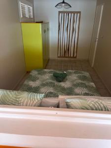 a bed in a room with a yellow cabinet at Milles Eclats in Les Anses-dʼArlets