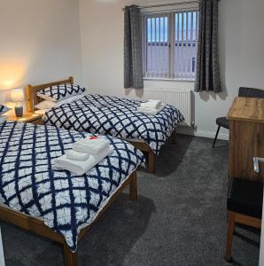 a bedroom with two beds with towels on them at Inverloch self catering in Orkney