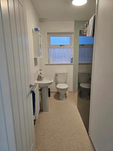 a bathroom with a white toilet and a sink at Inverloch self catering in Orkney +4 photos