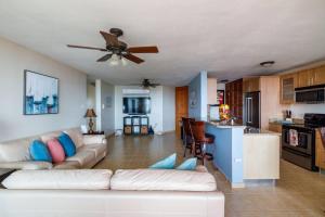a living room with a white couch and a kitchen at Island Escape in Fajardo