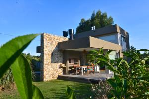 a brick house with a table in front of it at Samay Huasi - Cabañas y Casa de Te in Chapadmalal
