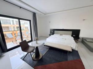 a bedroom with a bed and a chair and a couch at Easyhome in Brazzaville