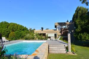 a villa with a swimming pool and a house at Samay Huasi - Cabañas y Casa de Te in Chapadmalal