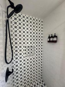 a bathroom with a shower with black and white tiles at Waterfront Escape HotTub, Pets OK, Pool Table in Dennis +28 photos