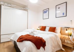 a bedroom with a large bed with white sheets and orange pillows at weroomies - Pons Icar H1 in Tarragona