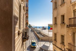 a yellow car parked in a street between two buildings at weroomies - Pons Icar H1 in Tarragona