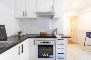 a kitchen with white cabinets and a stove at weroomies - Pons Icar H1 in Tarragona