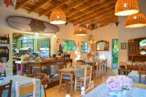 a restaurant with tables and chairs and chandeliers at Samay Huasi - Cabañas y Casa de Te in Chapadmalal