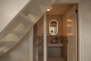 a hallway with a staircase with a sink and a mirror at Bommartini Guesthouse in Enschede +24 photos