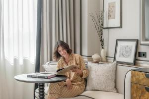 a woman sitting on a chair reading a book at BLESS Barcelona - New Opening 2026 in Barcelona +21 photos
