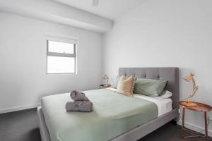 a teddy bear sitting on a bed in a bedroom at Atlantis - Coastal Retreat near Horseshoe Bay in Port Elliot