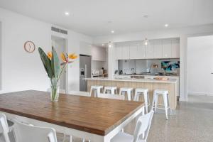 a kitchen and dining room with a wooden table and white chairs at Atlantis - Coastal Retreat near Horseshoe Bay in Port Elliot
