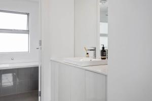 a white bathroom with a sink and a mirror at Atlantis - Coastal Retreat near Horseshoe Bay in Port Elliot +22 photos