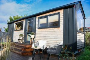 a tiny house with a deck and two chairs at Seebrise Adria in Altrip