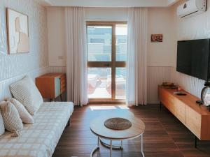 a living room with a couch and a tv and a table at Stylish Penthouse Beach Front in Ashkelon