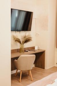 a room with a desk with a chair and a television at Hotel MB in Metković