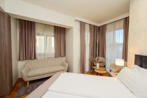 a bedroom with a bed and a couch and a chair at Hotel MB in Metković