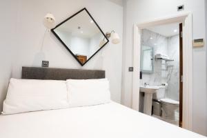 a bedroom with a white bed and a mirror at MSK Hotel 82 in London